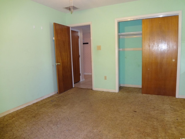 unfurnished bedroom featuring light carpet and a closet