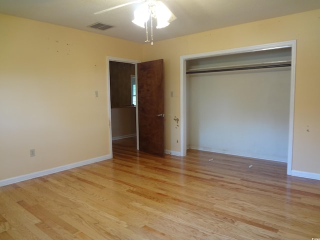 unfurnished bedroom with ceiling fan, a closet, and light wood-type flooring