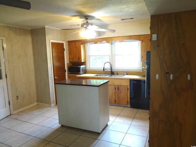 kitchen featuring ceiling fan, a center island, sink, black dishwasher, and light tile patterned floors