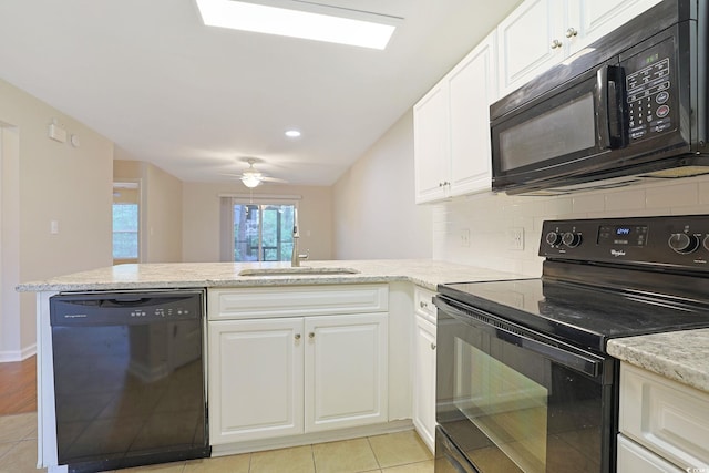 kitchen with black appliances, kitchen peninsula, and white cabinets