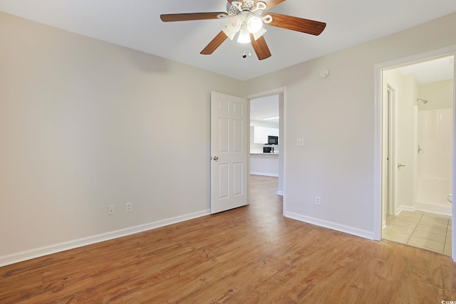 empty room with light hardwood / wood-style flooring and ceiling fan