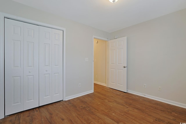 unfurnished bedroom with wood-type flooring and a closet