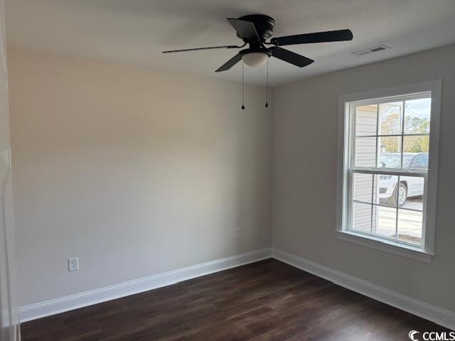 empty room featuring dark hardwood / wood-style floors and ceiling fan