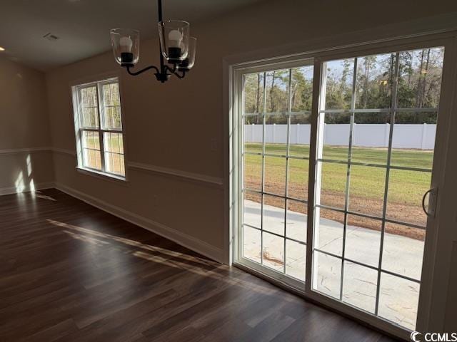 doorway with dark hardwood / wood-style flooring, plenty of natural light, and a chandelier