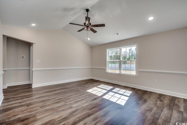 unfurnished room with wood finished floors, a ceiling fan, visible vents, baseboards, and vaulted ceiling