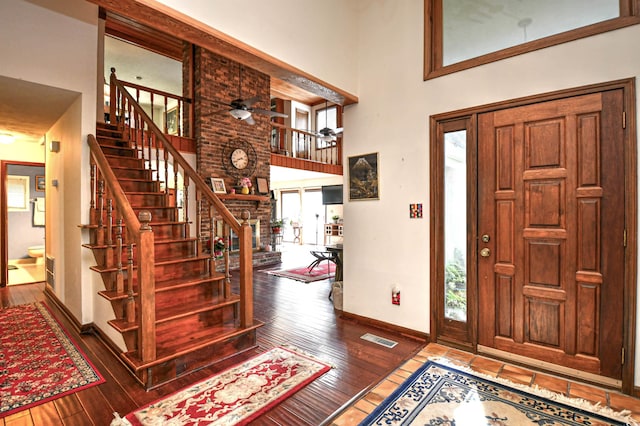 entryway featuring wood-type flooring, a high ceiling, and ceiling fan