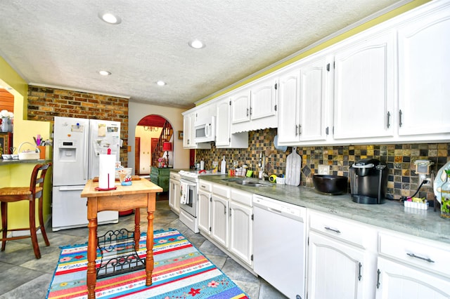 kitchen featuring a textured ceiling, sink, white appliances, and white cabinetry