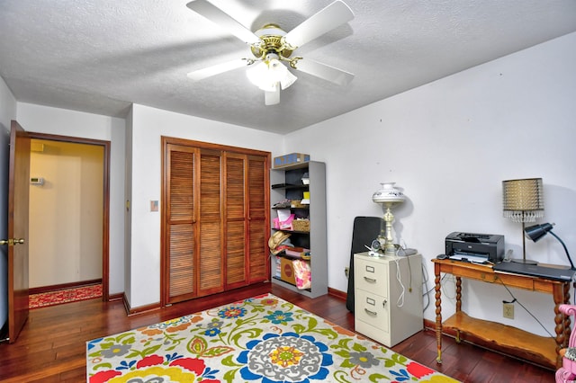 bedroom with a textured ceiling, dark hardwood / wood-style floors, ceiling fan, and a closet