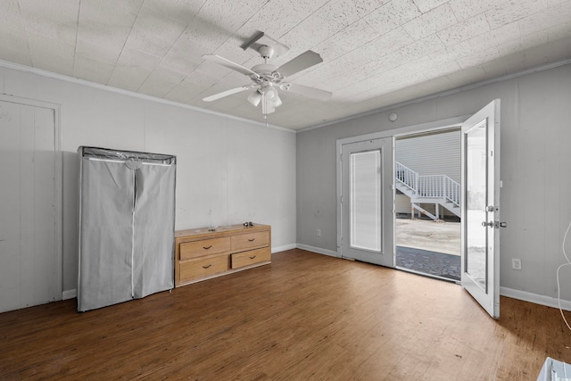 unfurnished bedroom with dark wood-type flooring, ceiling fan, crown molding, and access to exterior