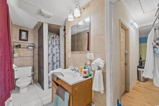 bathroom with vanity, toilet, tile walls, and hardwood / wood-style floors