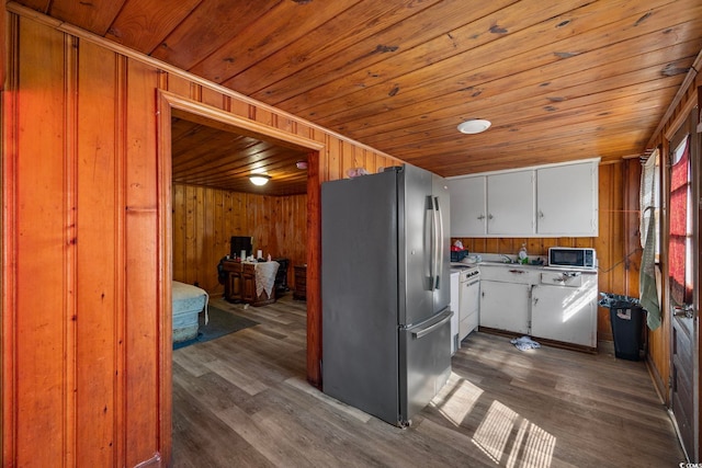 kitchen with dark hardwood / wood-style floors, appliances with stainless steel finishes, and wooden walls