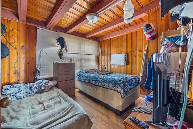 bedroom with wooden ceiling, hardwood / wood-style floors, beam ceiling, and wooden walls