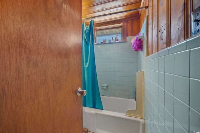 bathroom featuring wooden walls and shower / bath combo with shower curtain