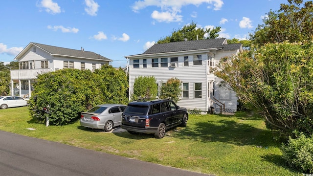 colonial-style house with a balcony and a front yard