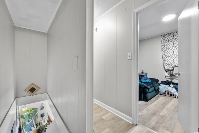 hallway featuring light hardwood / wood-style flooring and ornamental molding