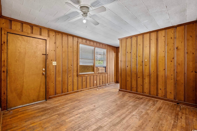 entryway featuring ceiling fan, wooden walls, cooling unit, hardwood / wood-style flooring, and a textured ceiling