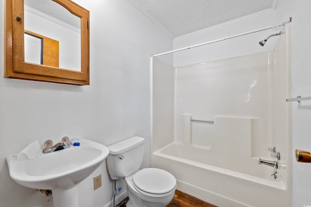 full bathroom with wood-type flooring, tub / shower combination, toilet, and a textured ceiling