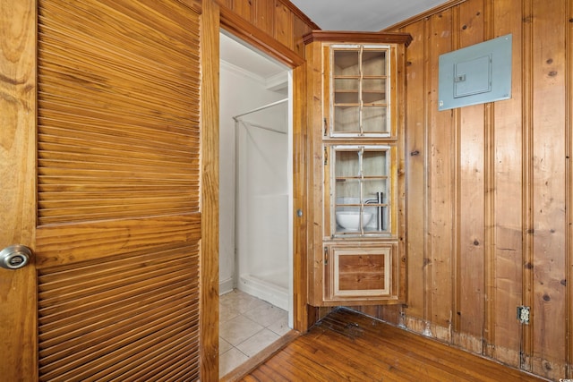 bathroom with ornamental molding, wooden walls, and wood-type flooring