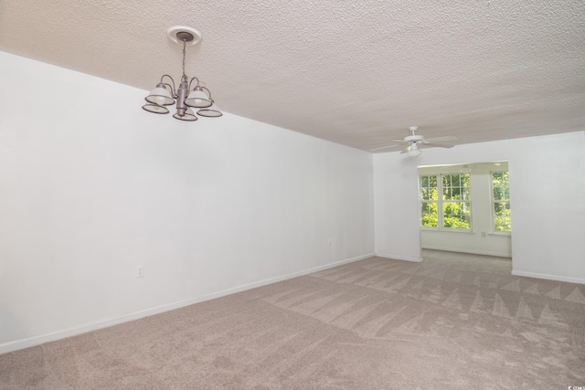 empty room with light carpet, a textured ceiling, and ceiling fan with notable chandelier