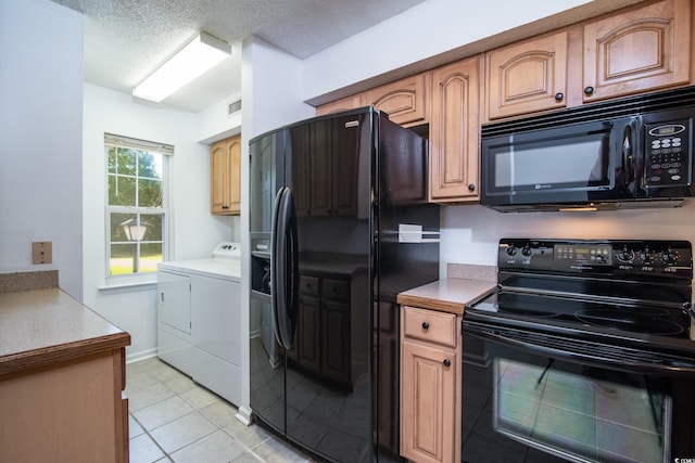 kitchen featuring separate washer and dryer, light tile patterned floors, black appliances, and a textured ceiling