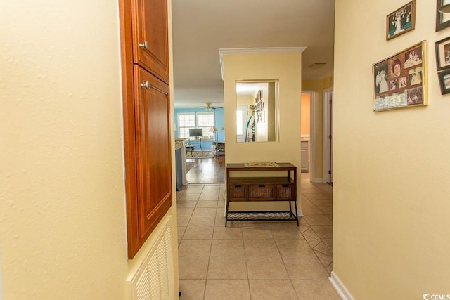 corridor with ornamental molding and light tile patterned floors