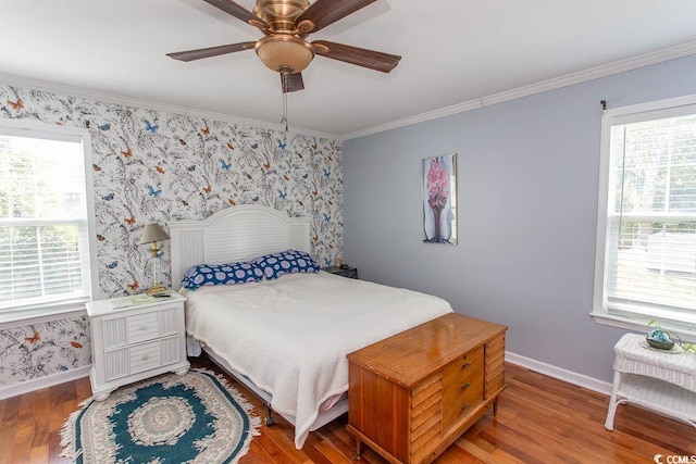 bedroom featuring ceiling fan, ornamental molding, and wood-type flooring