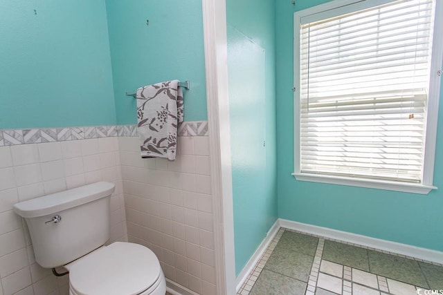 bathroom featuring tile walls, tile patterned flooring, toilet, and a healthy amount of sunlight