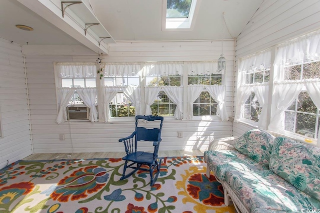 sunroom with cooling unit, a wealth of natural light, and vaulted ceiling with skylight