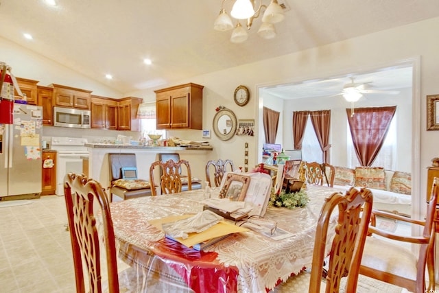 dining room with ceiling fan with notable chandelier and lofted ceiling