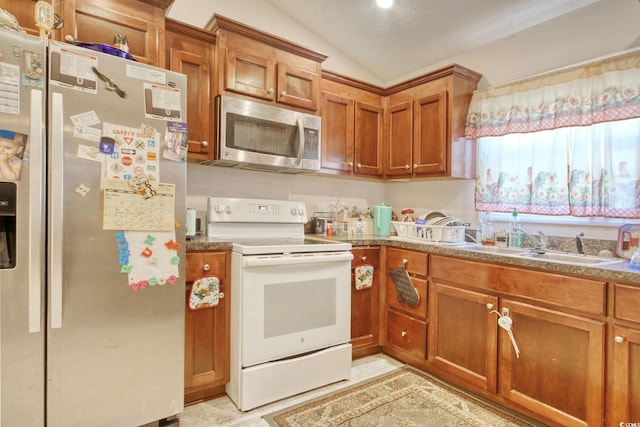 kitchen with appliances with stainless steel finishes and vaulted ceiling