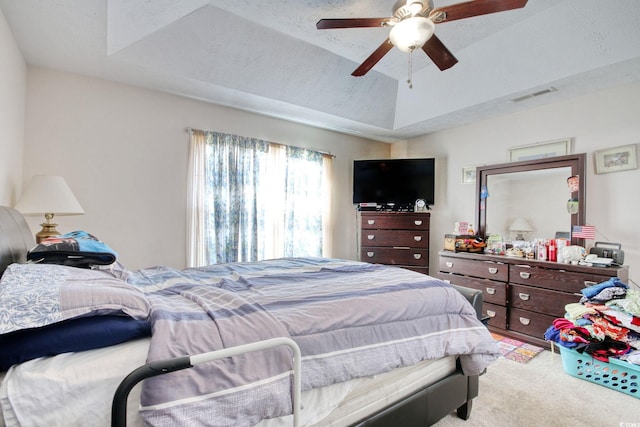 bedroom featuring carpet, ceiling fan, and a raised ceiling