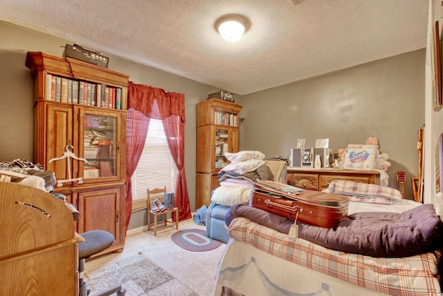 bedroom with light carpet and a textured ceiling