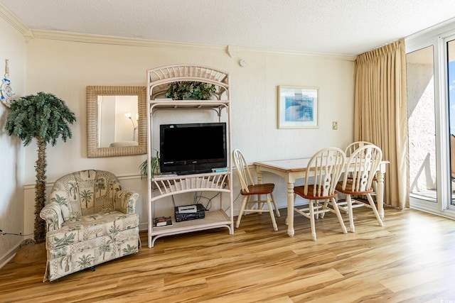 dining space with ornamental molding, hardwood / wood-style floors, and a textured ceiling