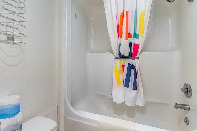 bathroom featuring shower / bath combo and toilet