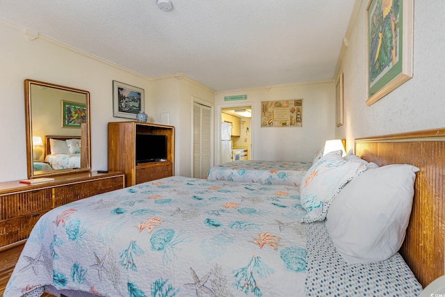 bedroom with hardwood / wood-style floors, crown molding, a closet, and a textured ceiling