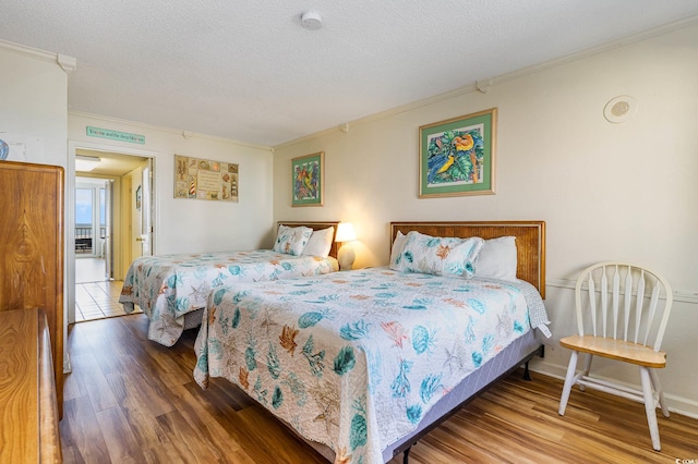 bedroom featuring wood-type flooring, a textured ceiling, and crown molding