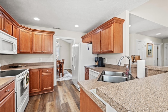 kitchen with dark hardwood / wood-style floors, sink, and white appliances