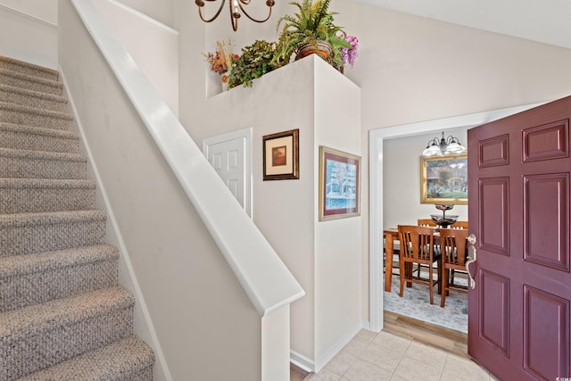 stairway featuring a towering ceiling, a chandelier, and wood-type flooring