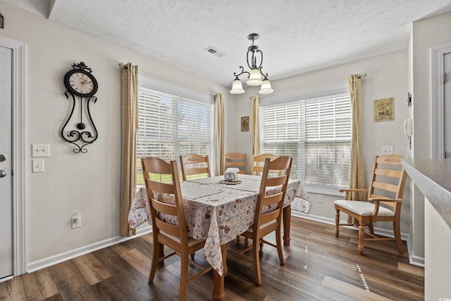 dining room with dark hardwood / wood-style floors and a textured ceiling