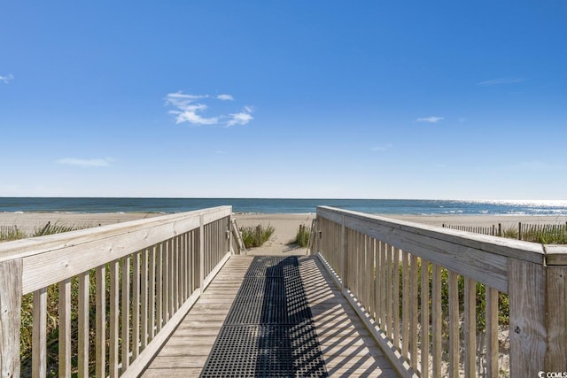 view of property's community with a water view and a beach view