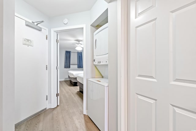 hall featuring light hardwood / wood-style floors and stacked washing maching and dryer