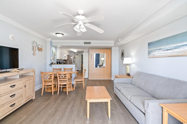 living room with light hardwood / wood-style flooring, ornamental molding, and ceiling fan