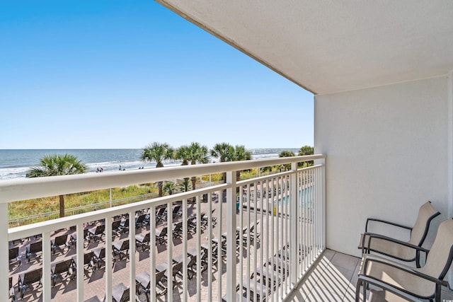 balcony with a water view and a beach view