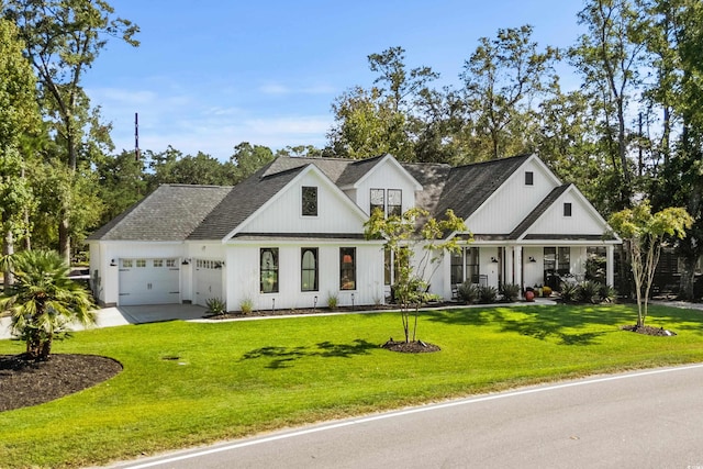 modern farmhouse featuring a front yard, a garage, and a porch