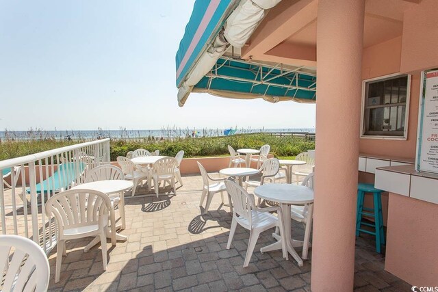 202 70th Ave N Unit 104, Myrtle Beach, SC 29572 - view of patio / terrace with view of water and beach and outdoor dining area