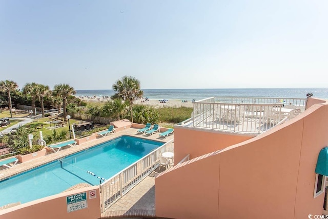 community pool featuring a water view and a patio area