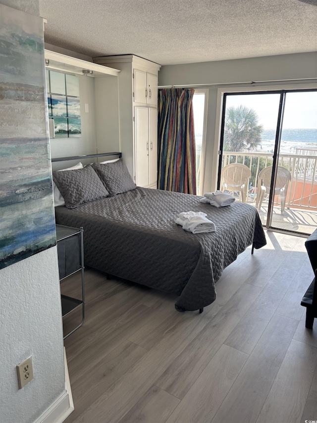 202 70th Ave N Unit 104, Myrtle Beach, SC 29572 - bedroom with access to exterior, wood finished floors, and a textured ceiling