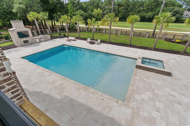 view of swimming pool with an in ground hot tub, a lawn, and a patio area