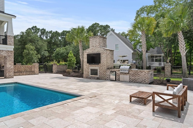 view of pool featuring grilling area, an outdoor kitchen, and a patio