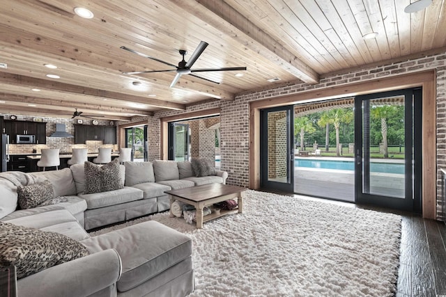 living room with beamed ceiling, a healthy amount of sunlight, dark wood-type flooring, and wood ceiling